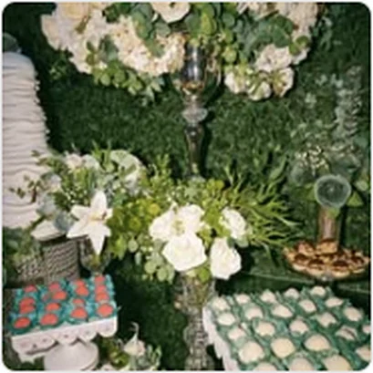 Mesa de doces com arranjos de flores em evento no Buffet Dream Hall