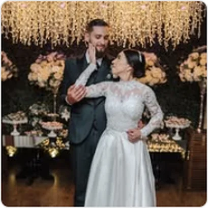 Noivos abraçados diante da decoração de flores em casamento no Buffet Dream Hall