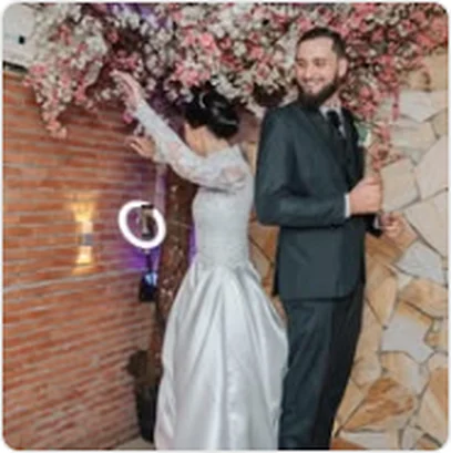 Noivos ao lado de parede de flores em casamento no buffet em Guarulhos