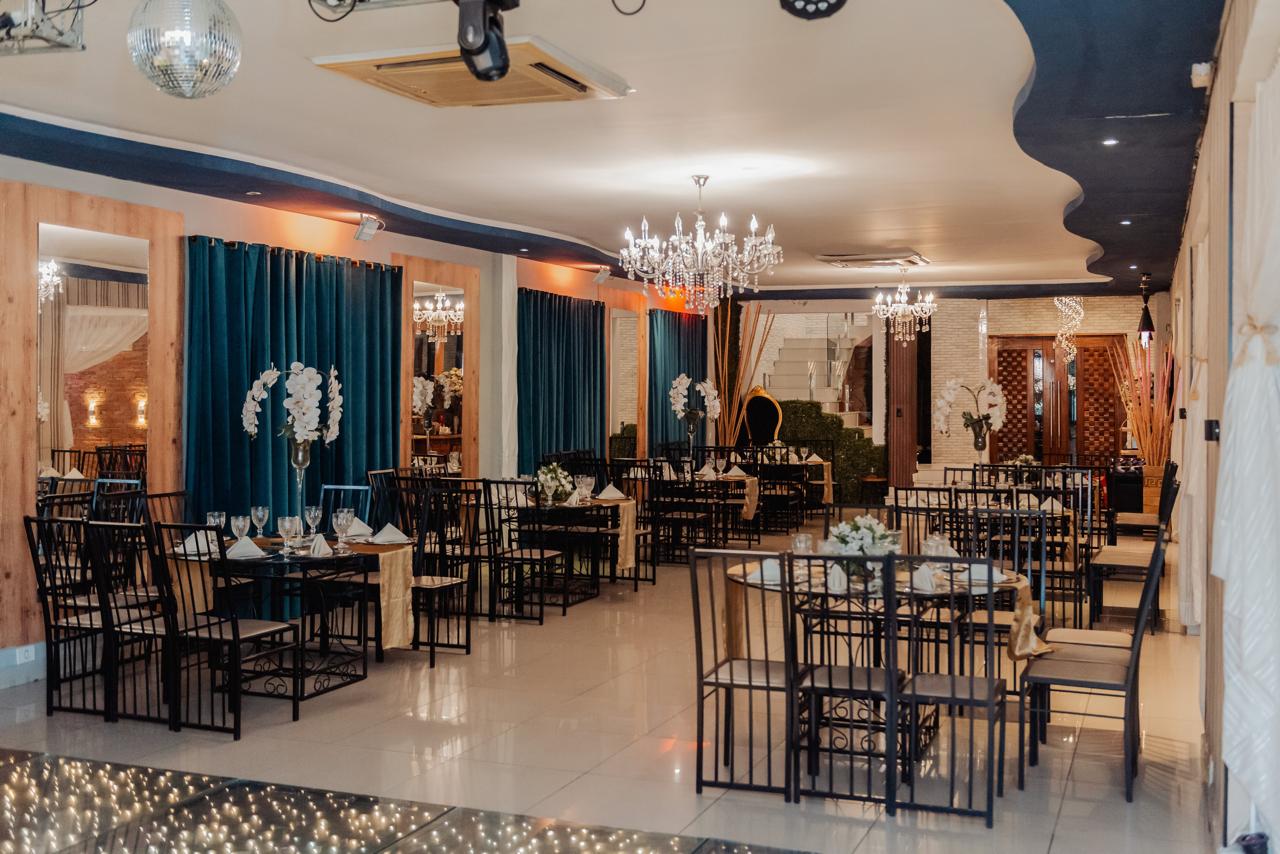Salão principal com mesas postas e lustres de cristal no Buffet Dream Hall em Guarulhos